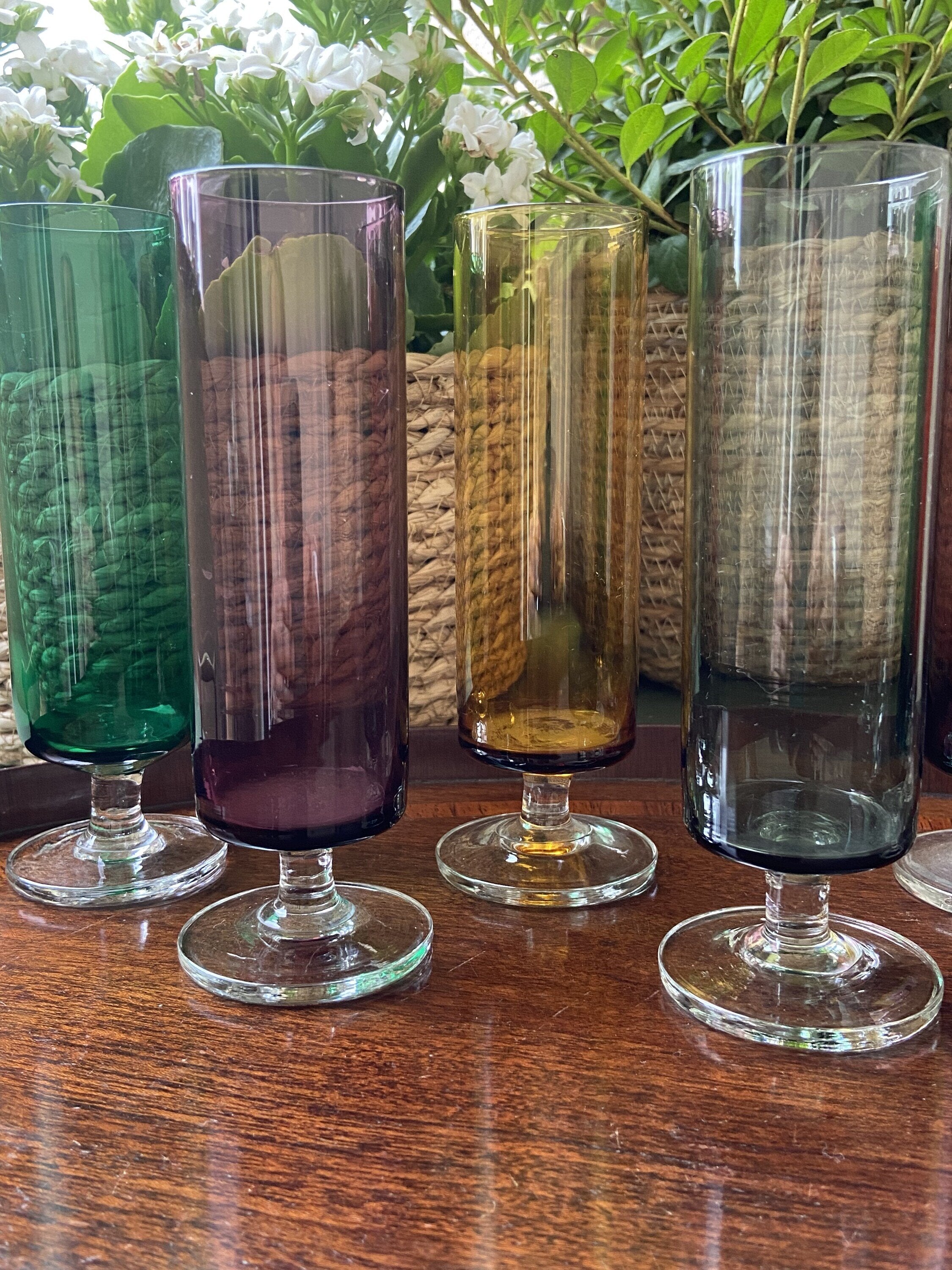 7 copas de cava en vidrio de diferentes colores.