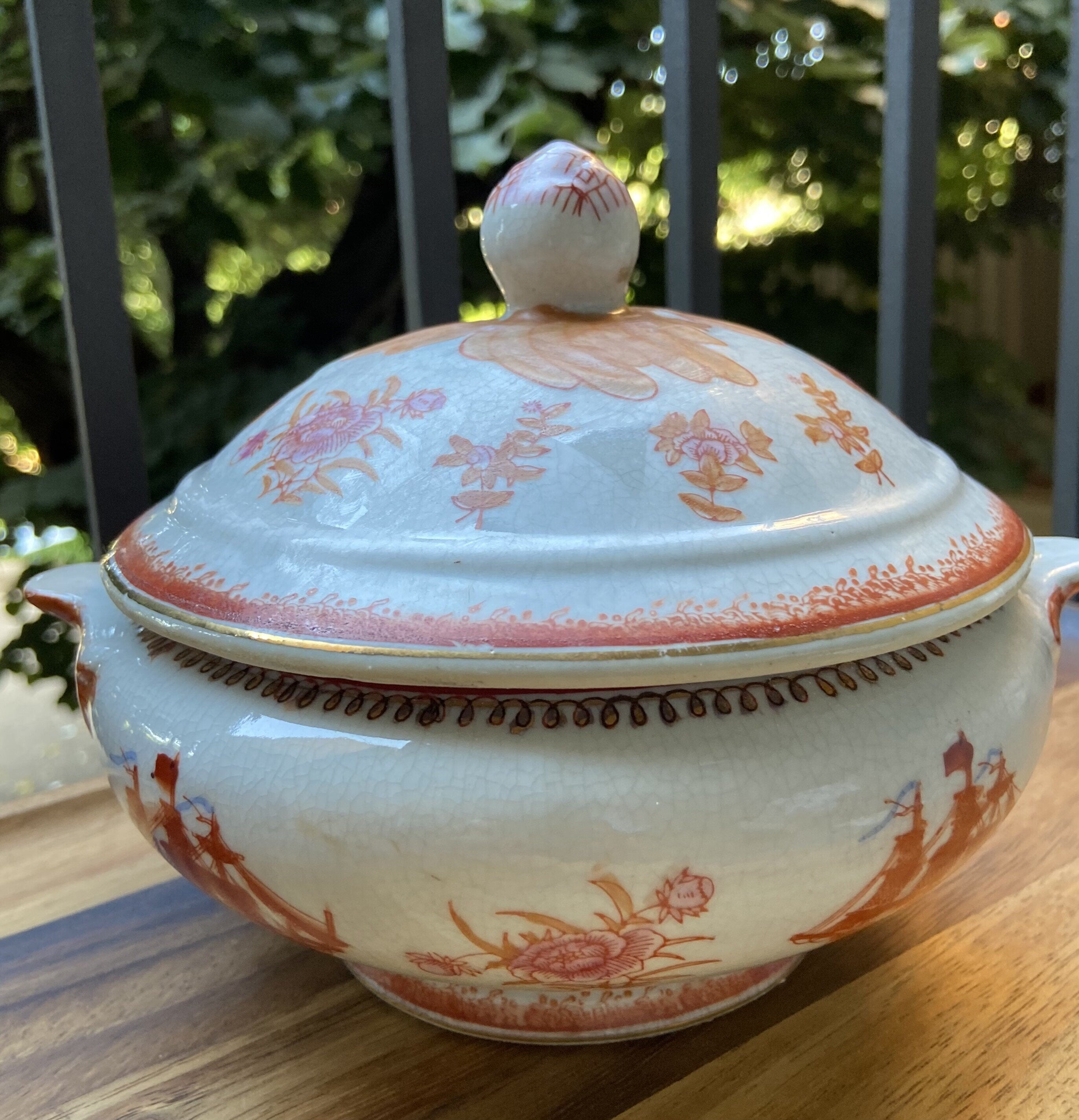 Vela en sopera de cerámica en tonalidades naranjas.