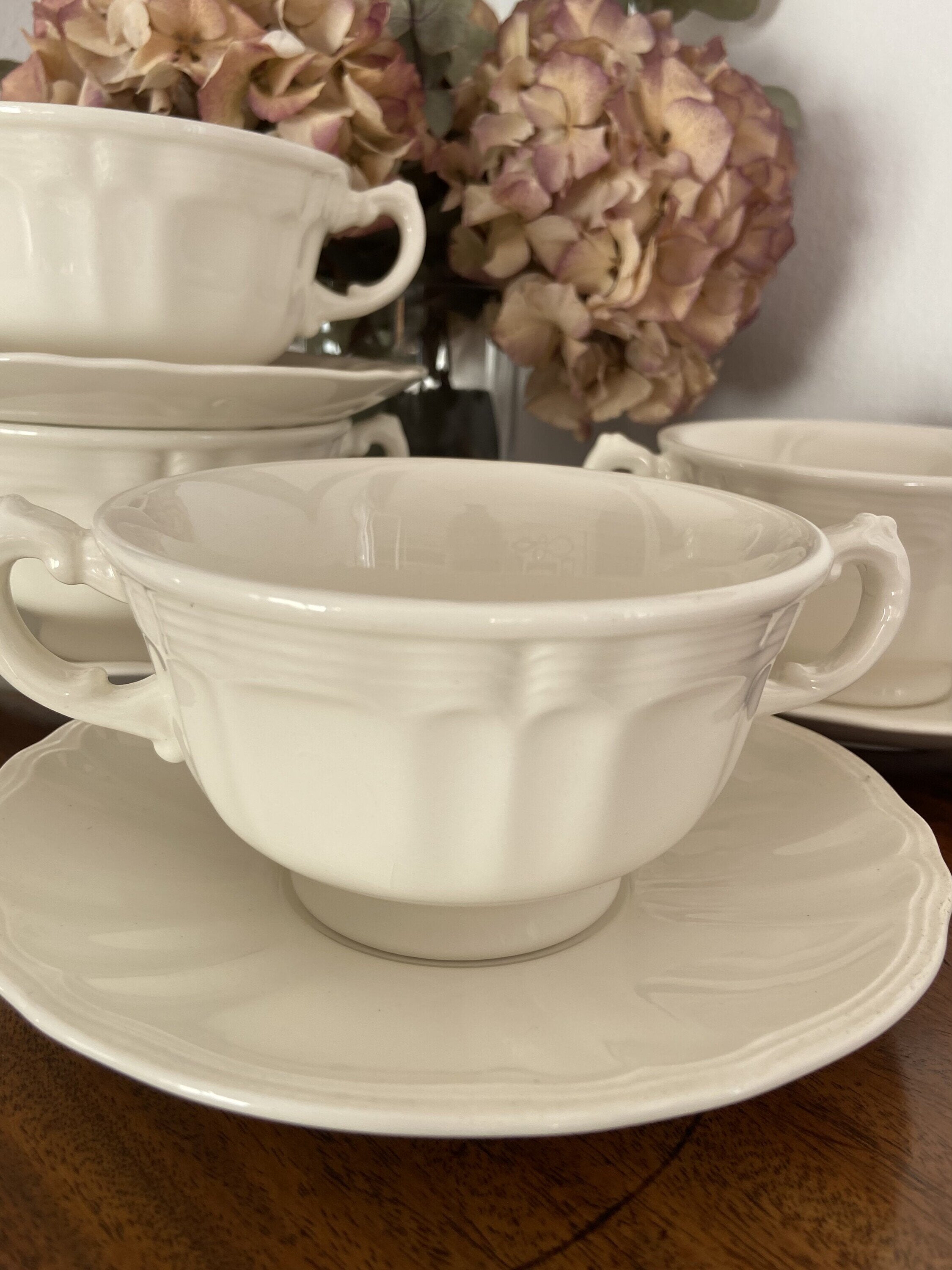 4 tazas de consomé en loza blanca.