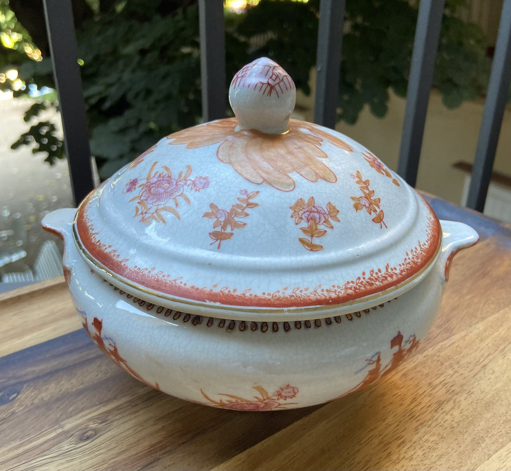 Vela en sopera de cerámica en tonalidades naranjas.