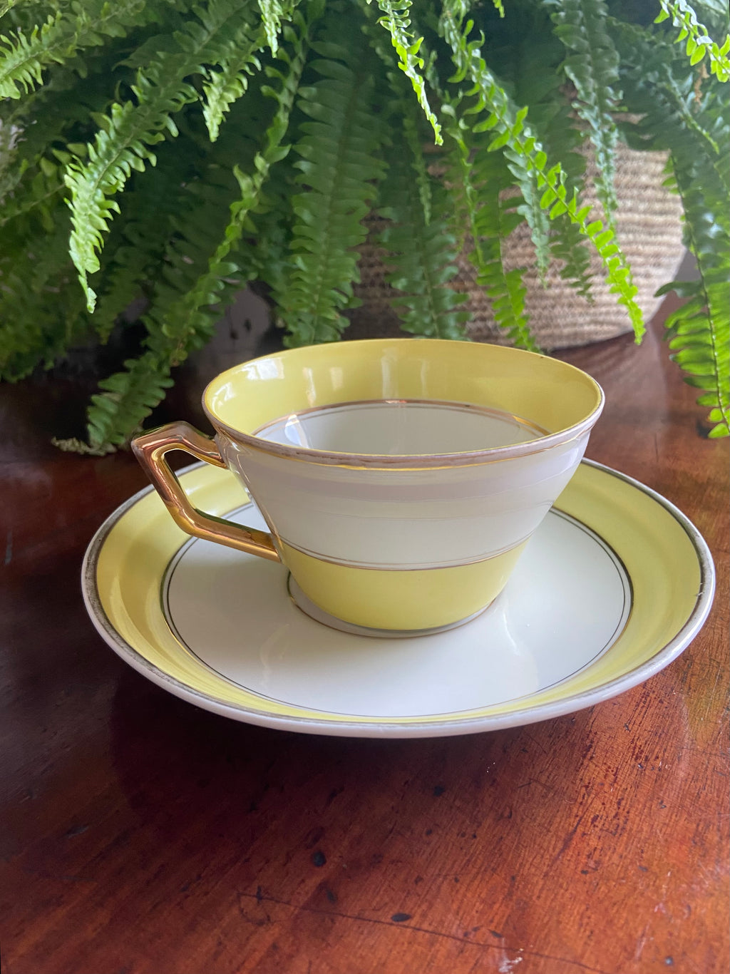 Taza de desayuno en porcelana blanca con franja amarilla.