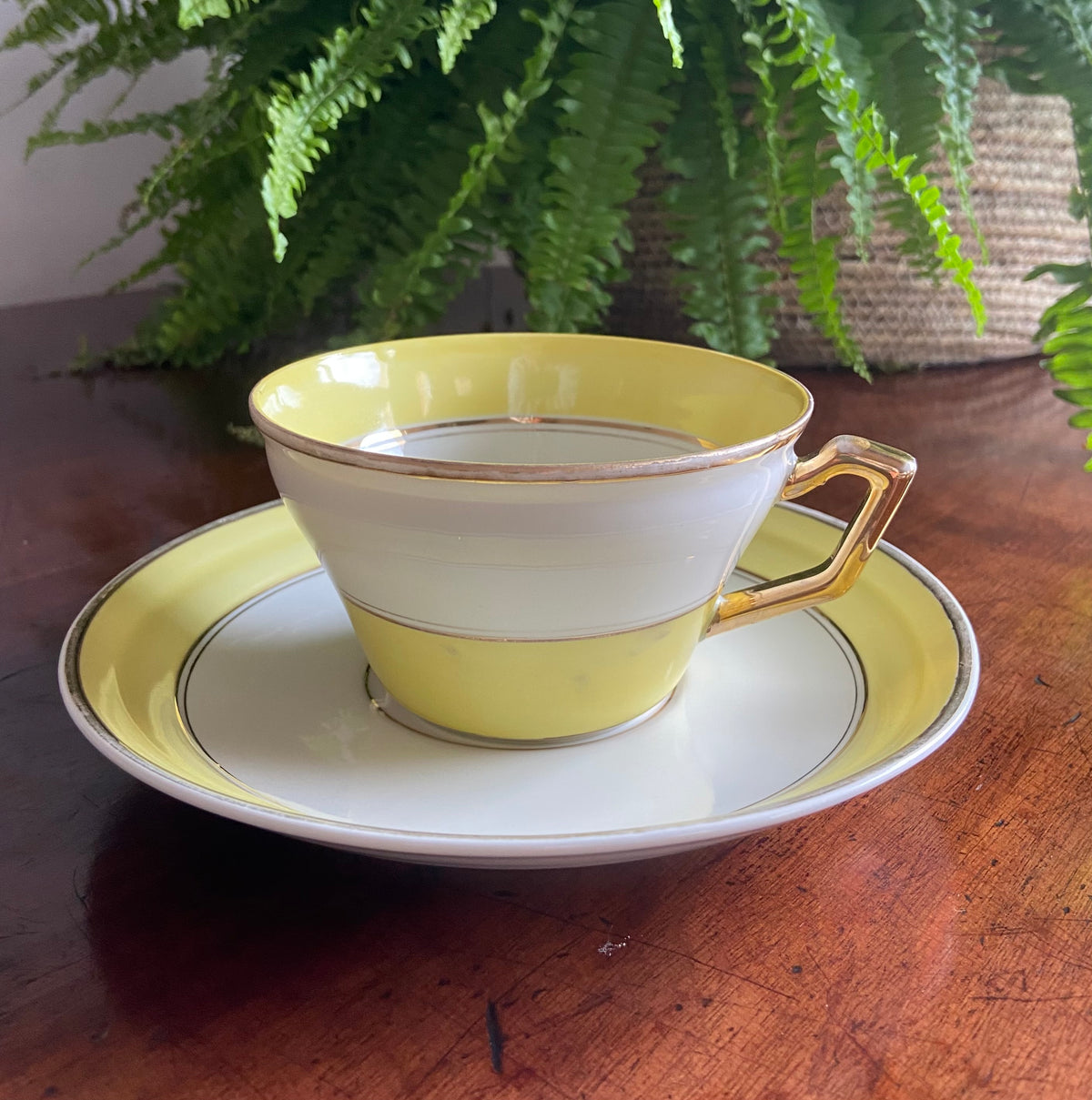 Taza de desayuno en porcelana blanca con franja amarilla.