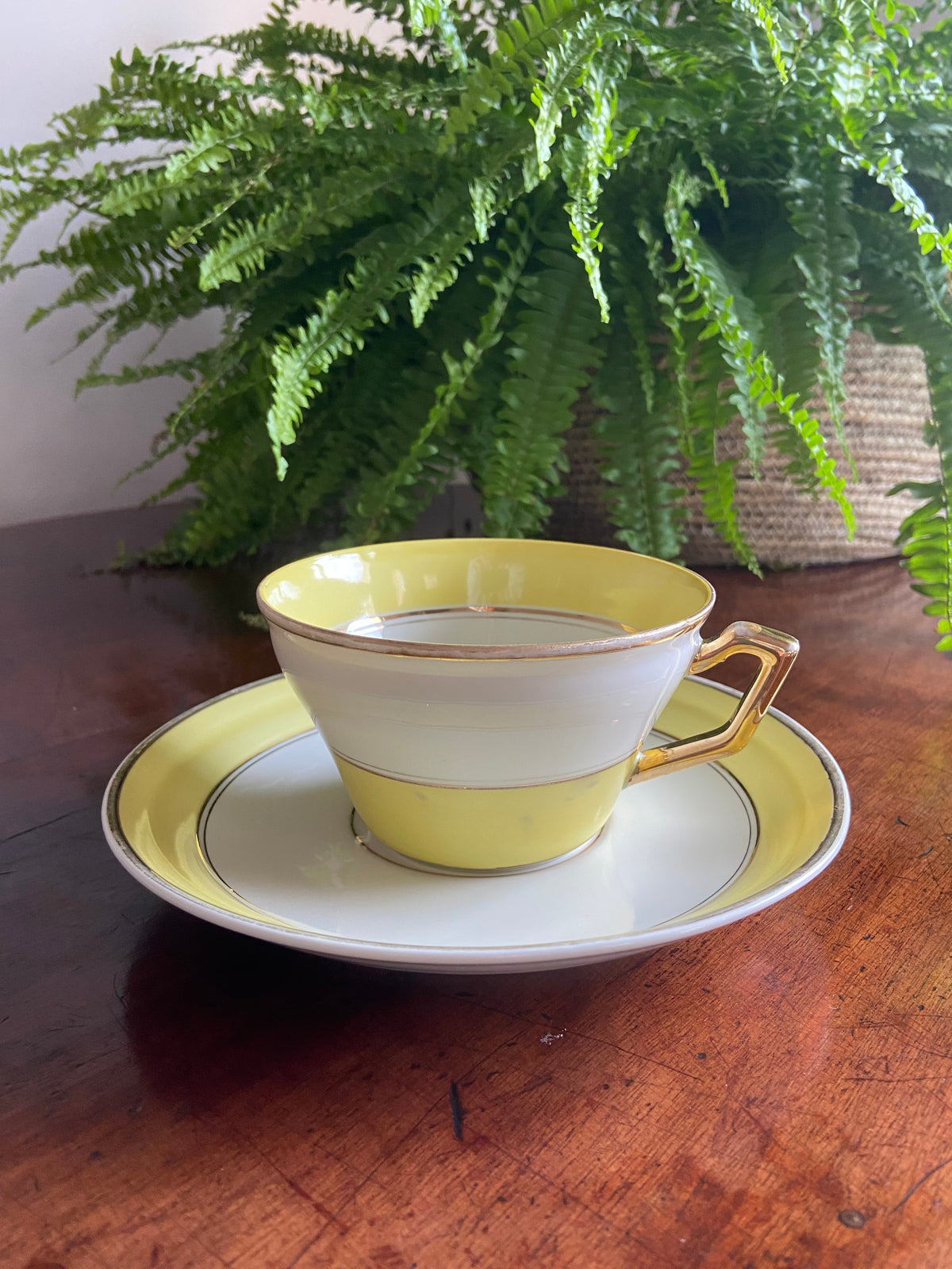 Taza de desayuno en porcelana blanca con franja amarilla.
