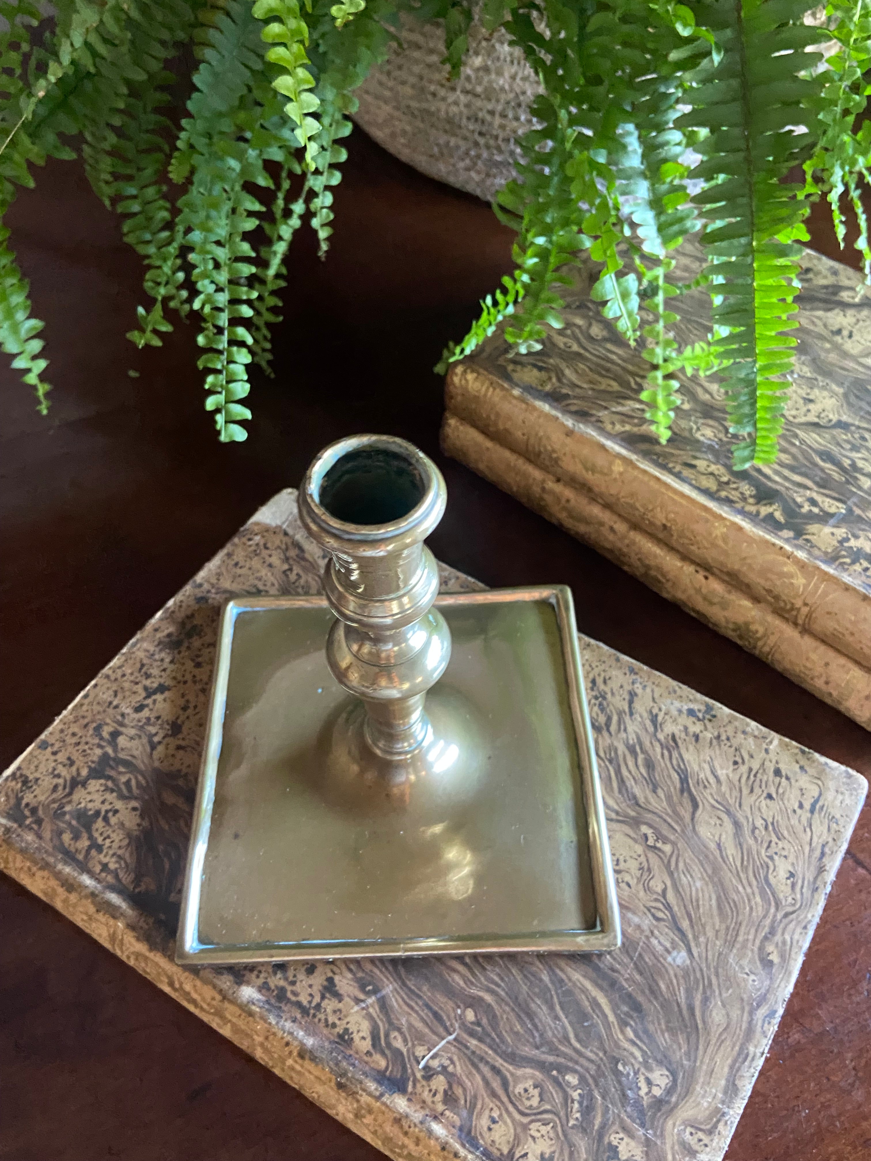 Candelabro de latón con base cuadrada.