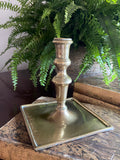 Candelabro de latón con base cuadrada.