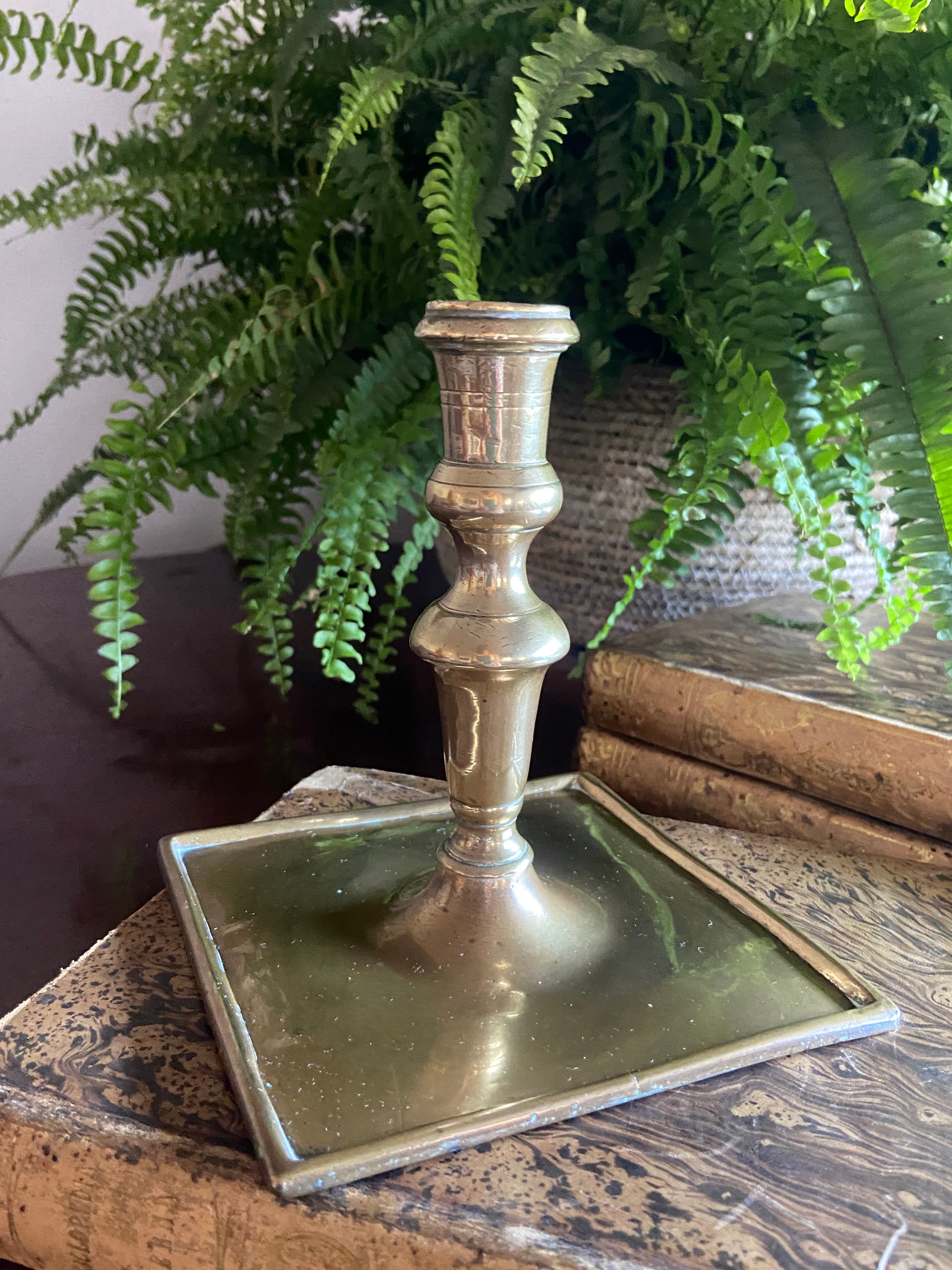 Candelabro de latón con base cuadrada.