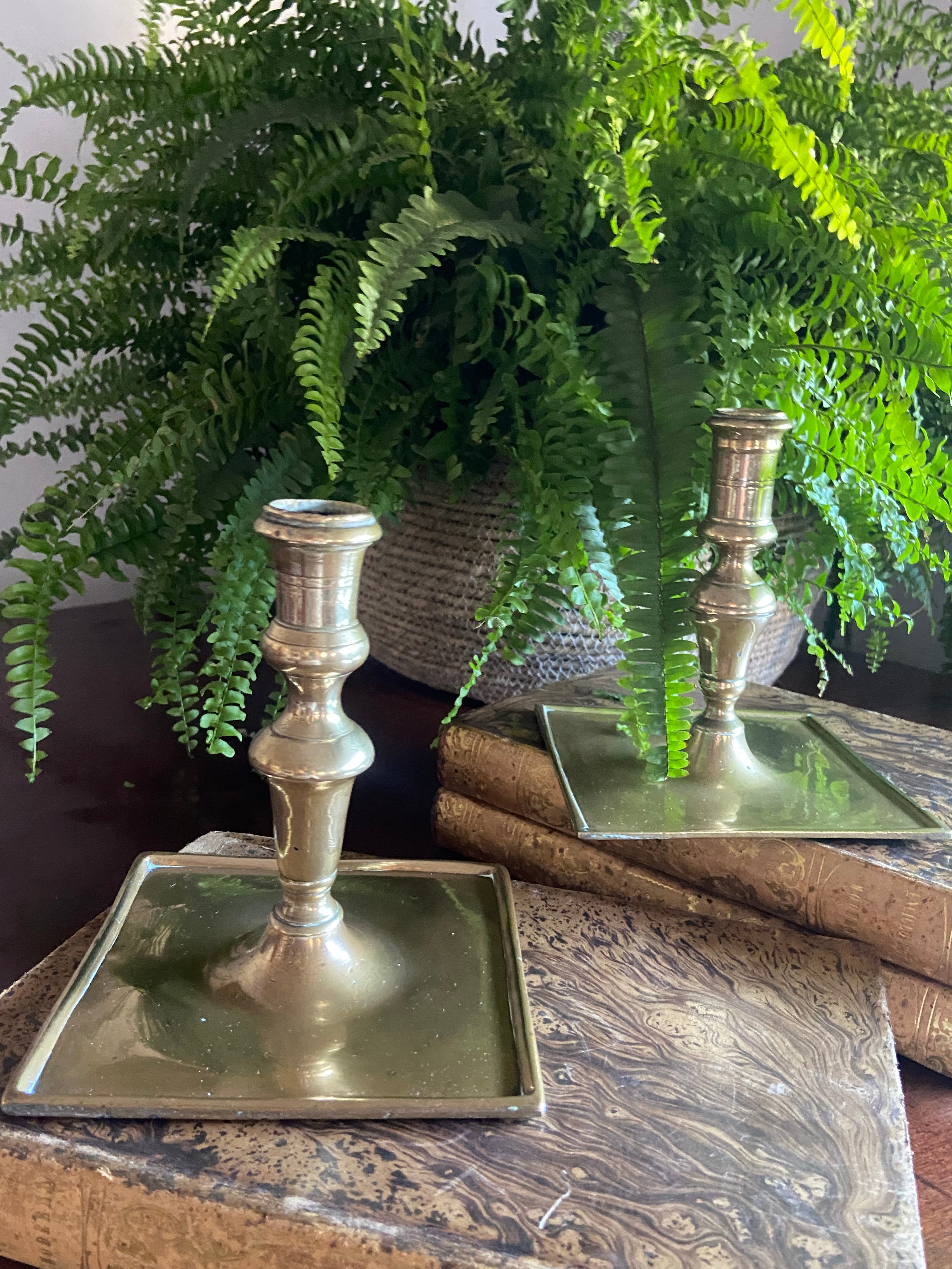 Candelabro de latón con base cuadrada.