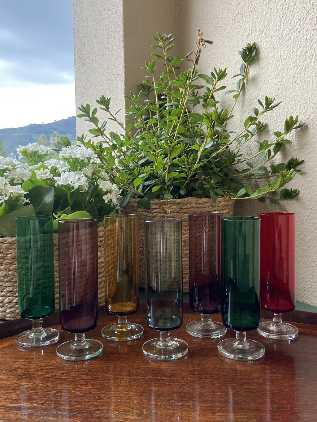 7 copas de cava en vidrio de diferentes colores.