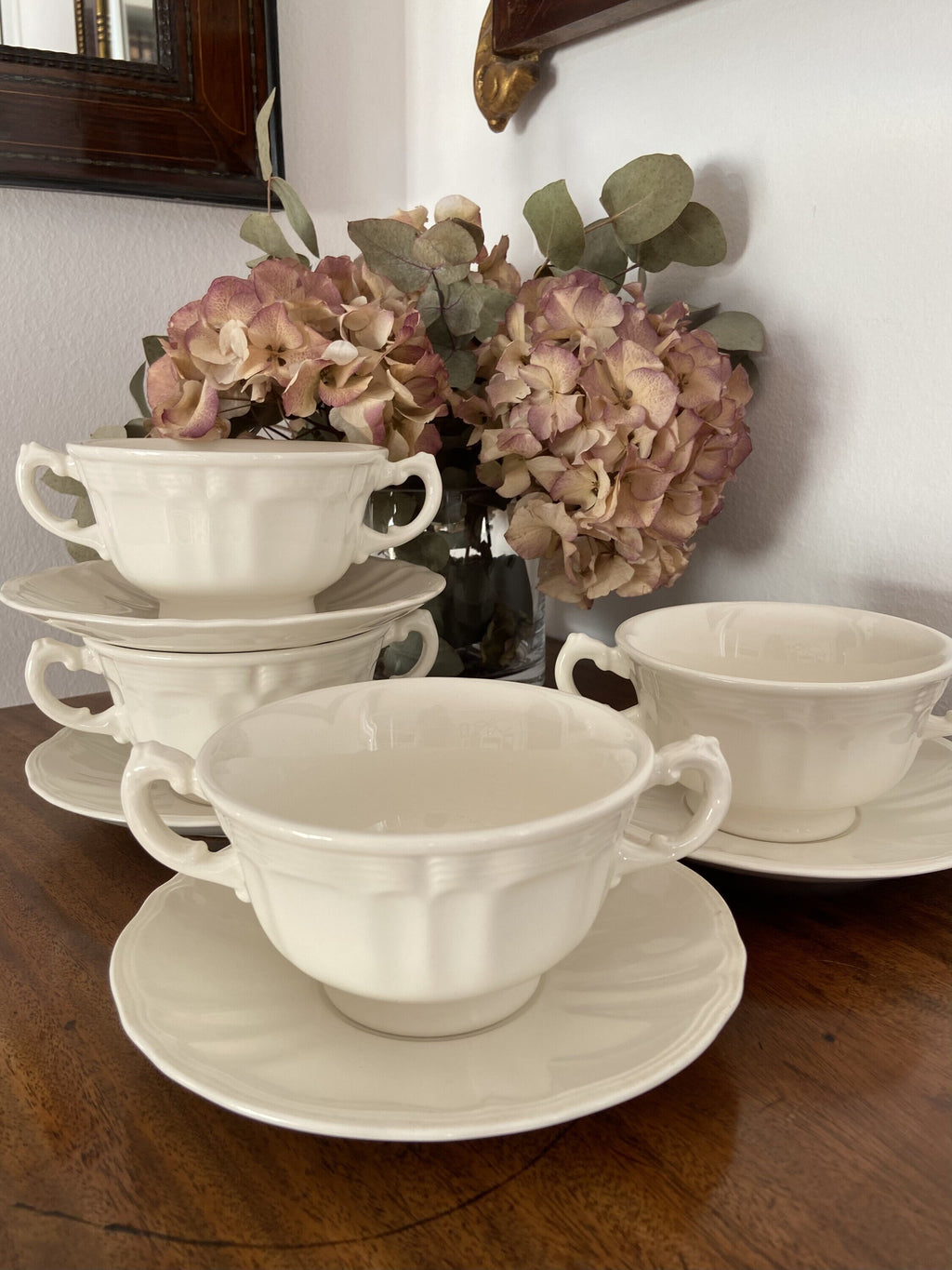 4 tazas de consomé en loza blanca.