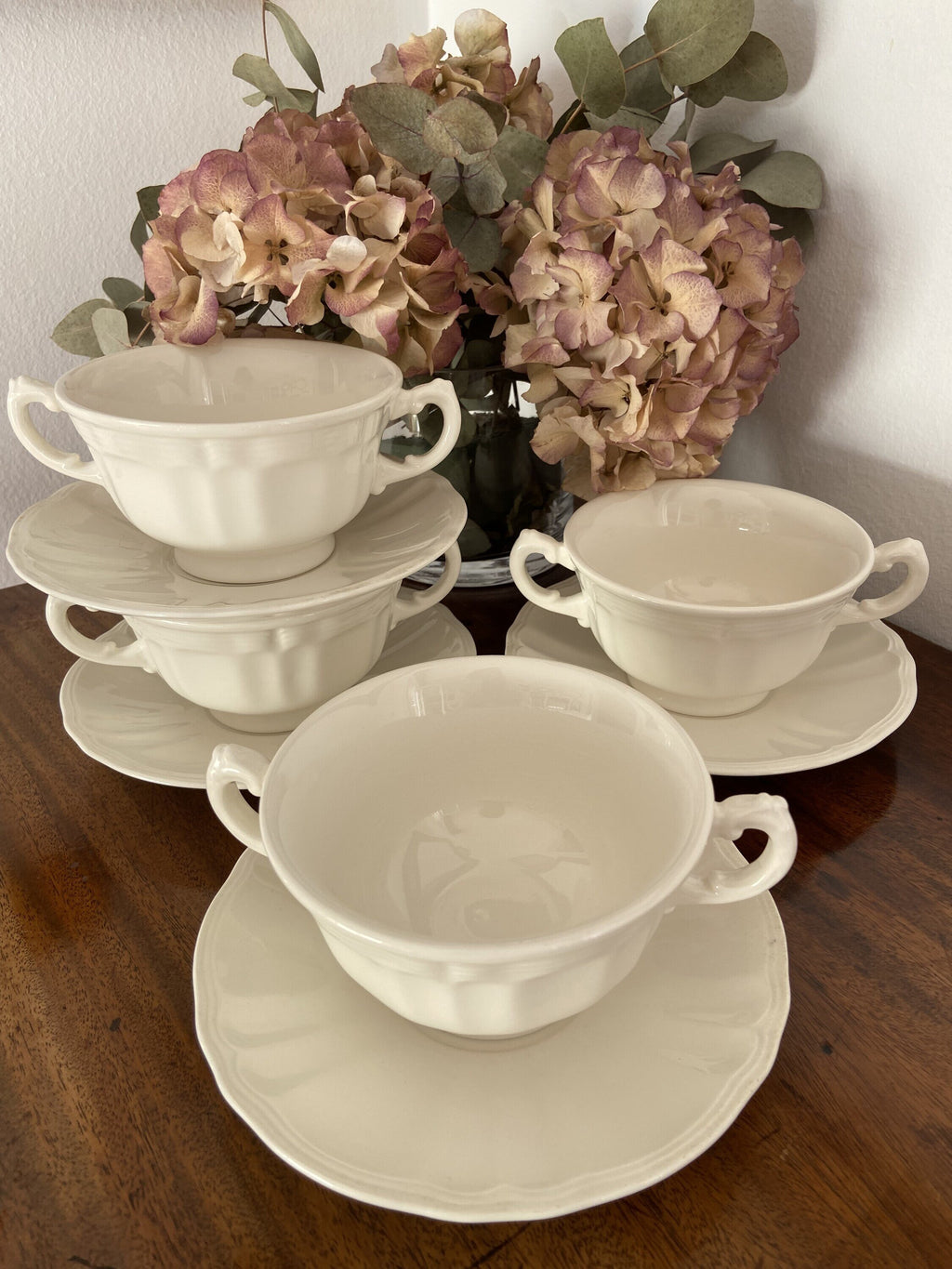 4 tazas de consomé en loza blanca.